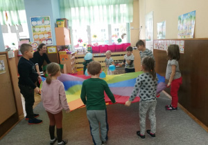 Zdjęcie przedstawia dzieci w trakcie zabawy chustą animacyjną
